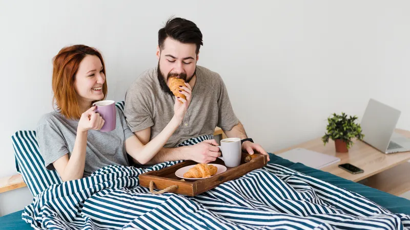 Junges Paar frühstückt im Bett
