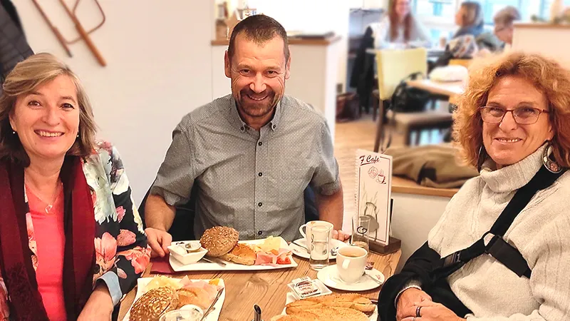 Eva und zwei Freunde gemeinsamen Frühstück
            