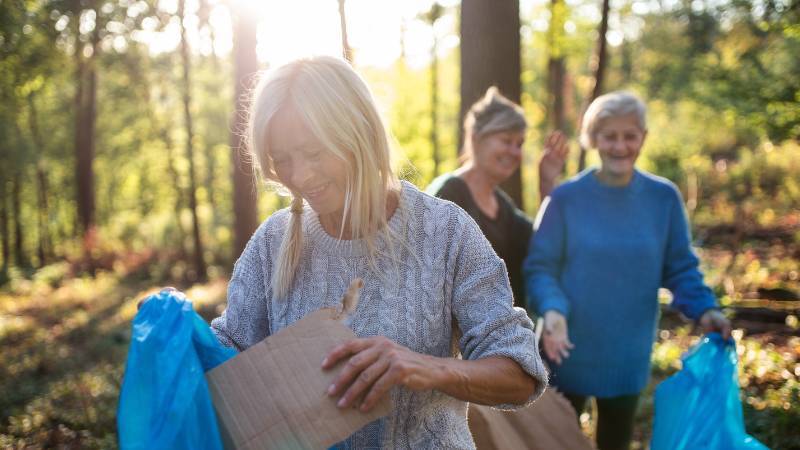 drei Frauen sammeln Müll im Wald