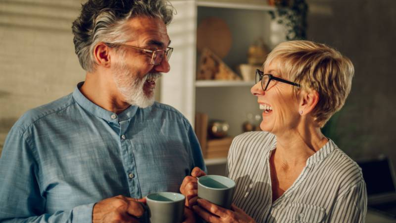 zwei ältere Personen trinken Kaffee und lachen