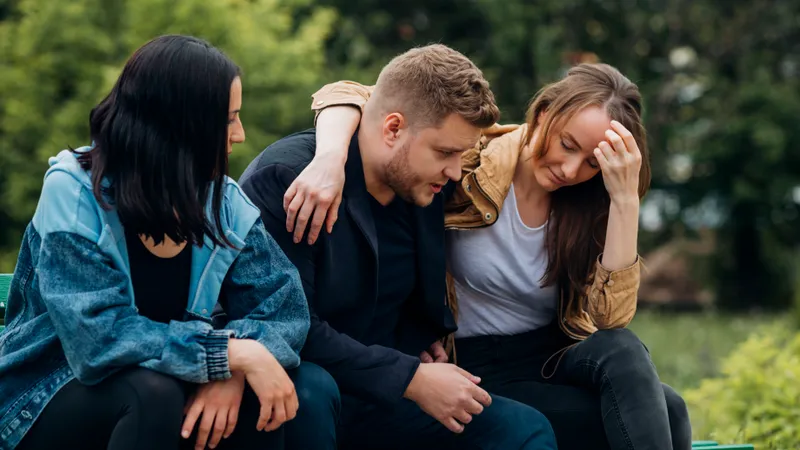 Drei Freunde sitzen im Park und sprechen über ihre Sorgen