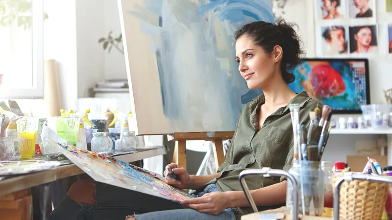 Frau sitzt vor einem Kunstwerk und denkt nach