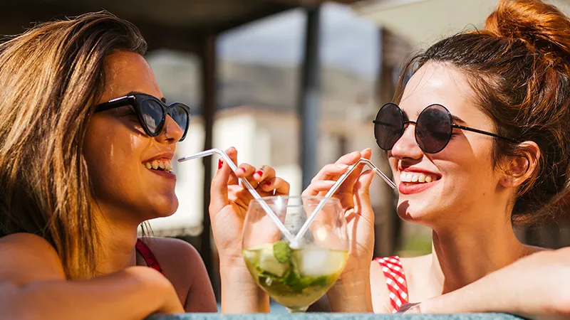  Zwei Freundinnen trinken einen Cocktail im Whirlpool