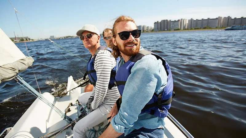 Drei Freunde unterschiedlichen Alters beim Segeln