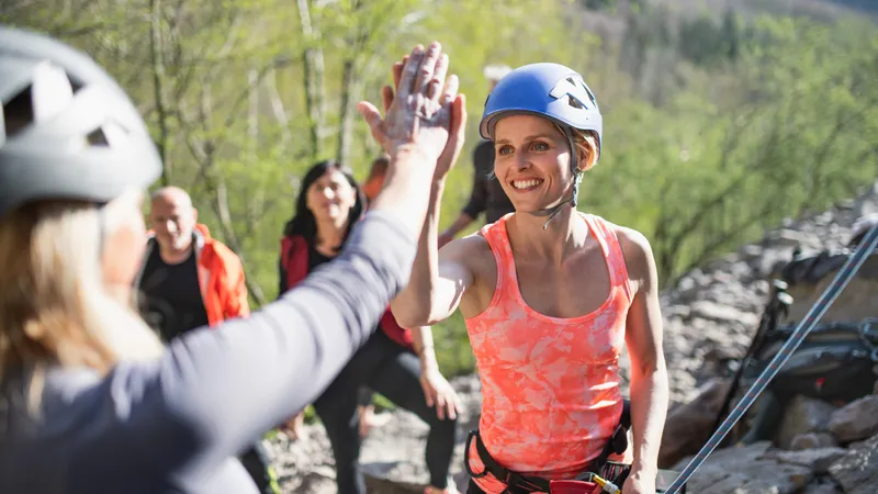 Zwei Freundinnen geben sich beim Klettern ein High-Five
