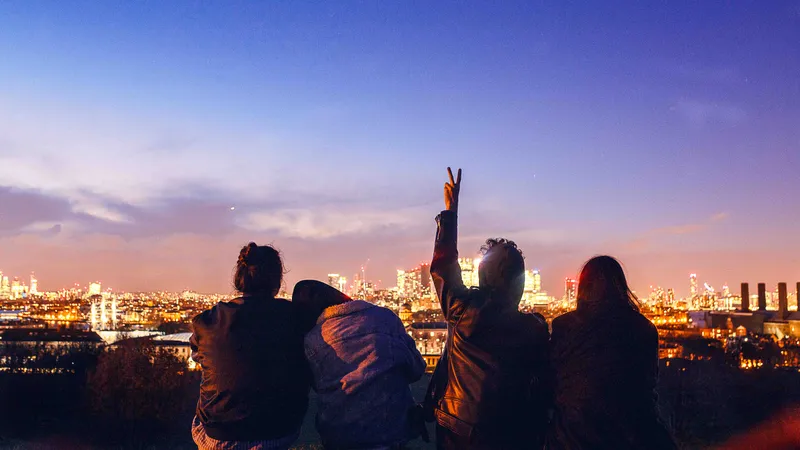 Vier Freunde beobachten den Sonnenuntergang über der Stadt