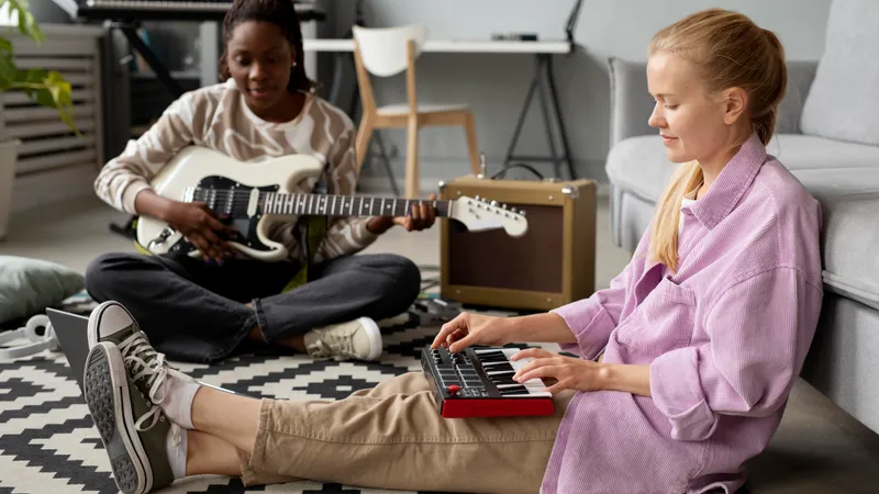 Zwei Freundinnen machen gemeinsam Musik mit Keyboard und E-Gitarre