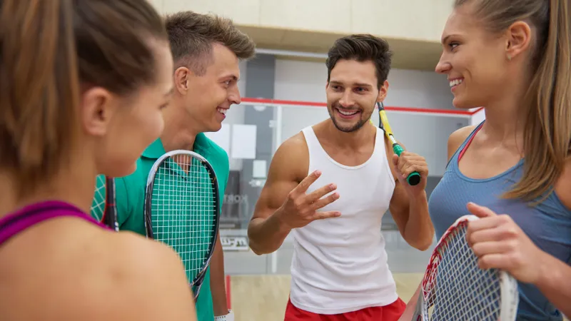 Vier Freunde besprechen ihr Tennis Match.