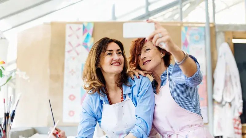Zwei Freundinnen machen ein Selfie beim Malen